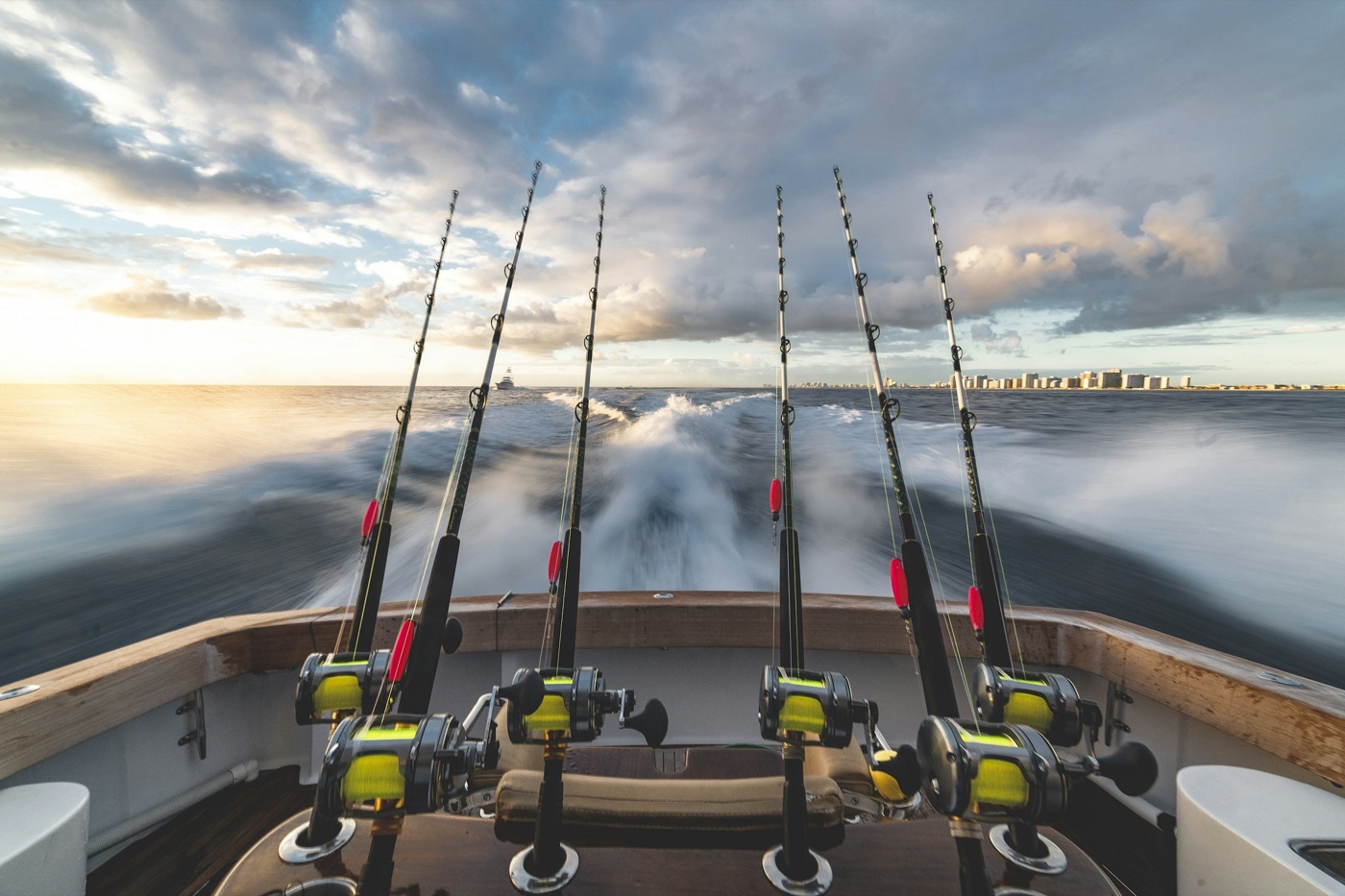 A row of rods and reels racked across the transom of a boat running offshore.