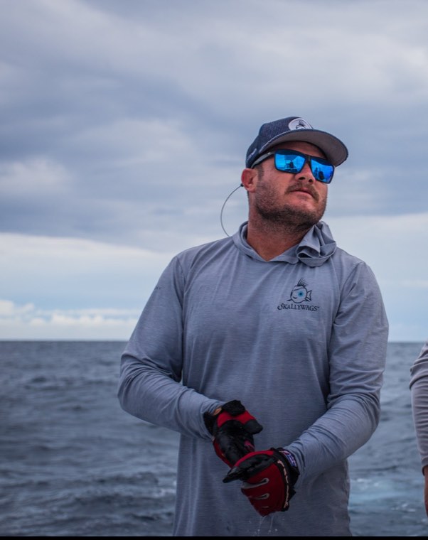 Captain Patrick McCafferty on deck offshore, gloved and watching the water.